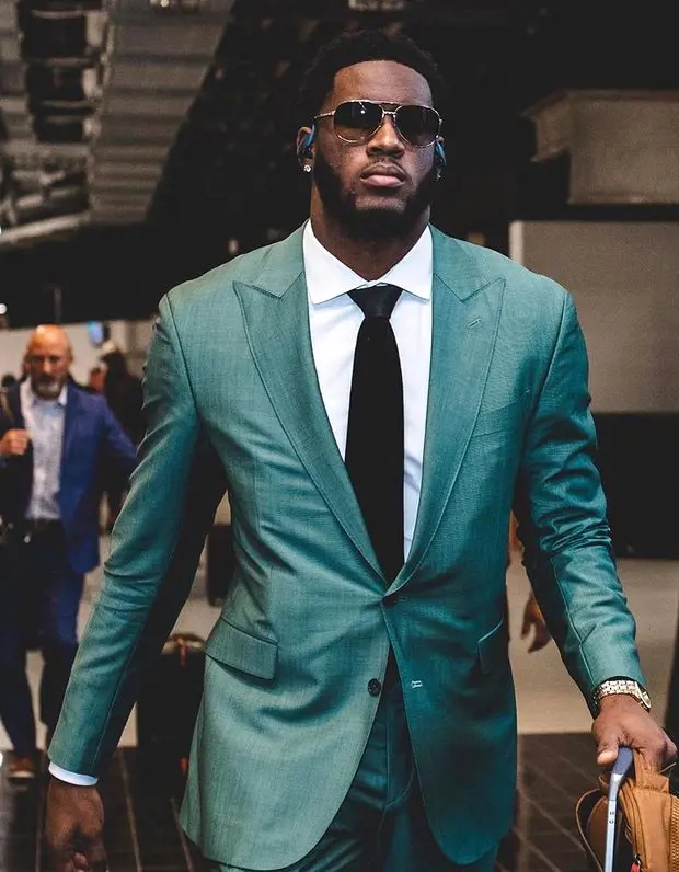 Brian looks handsome and elegant as he walks in a suit, tie along with sunglasses