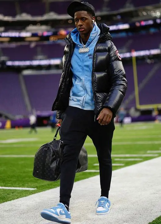 Sauce looks hot as he walks on the field carrying a Louis Vuitton bag
