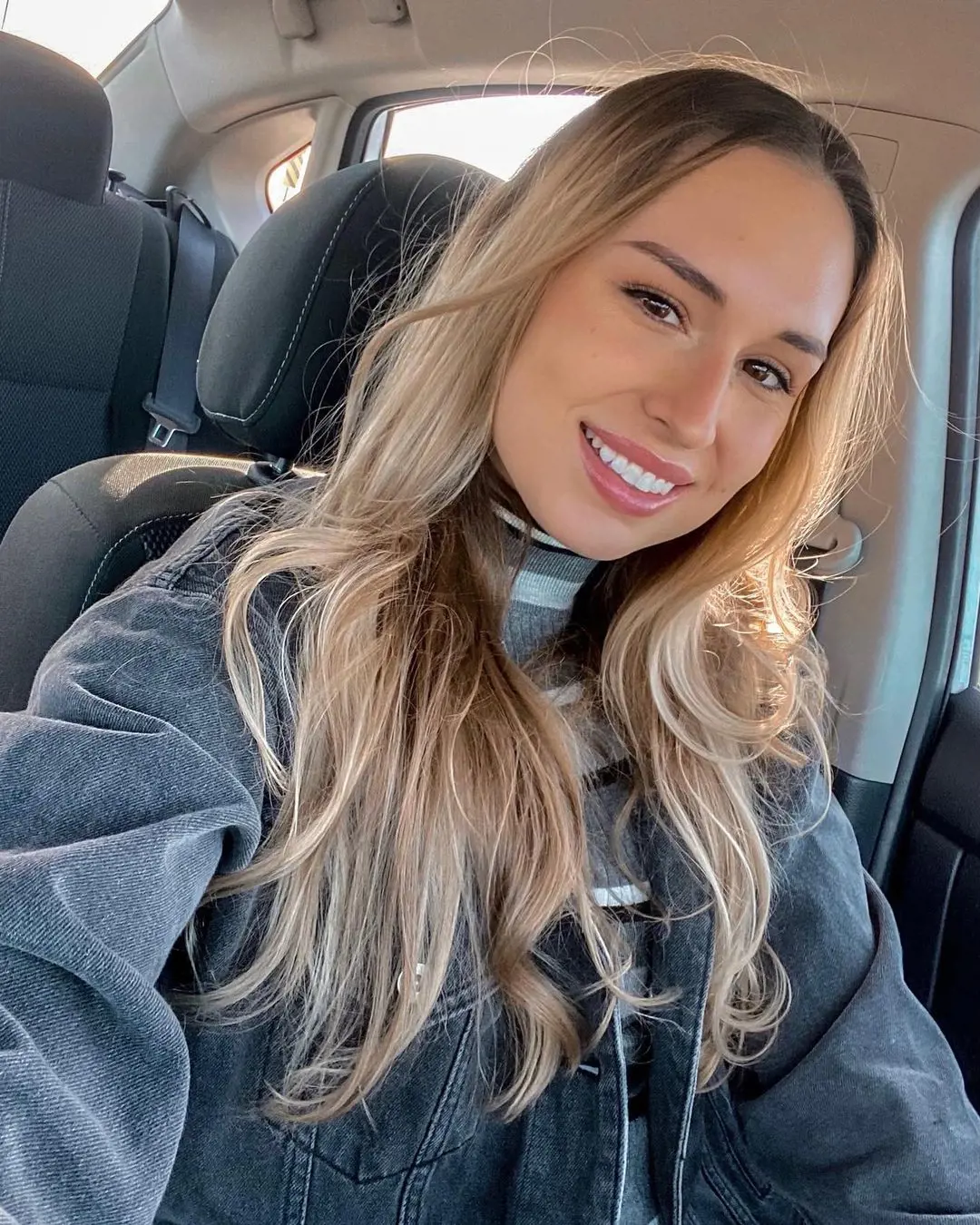 Becca taking a selfie on her car in 2021