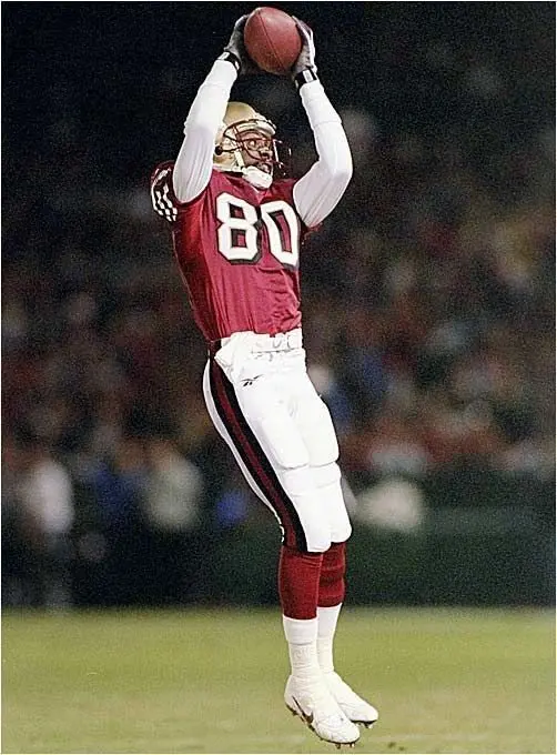 Jerry Rice in receiving the ball while representing the 49ers.