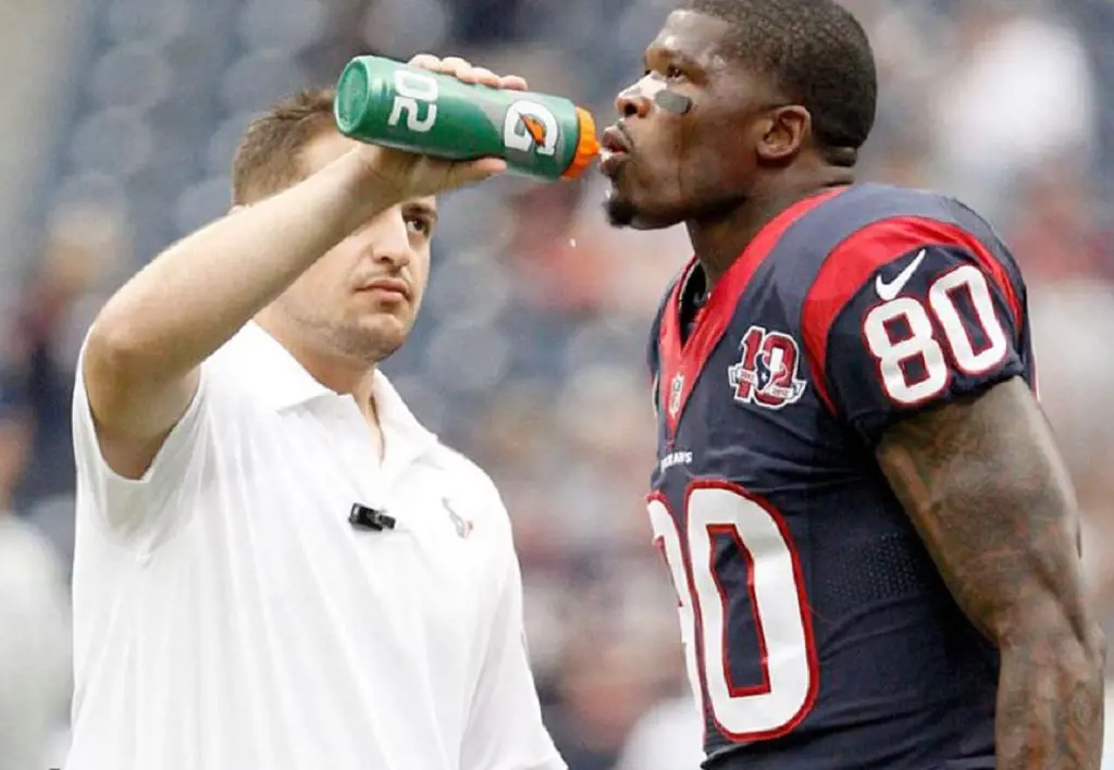 A Ballboy giving water to a NFL player.